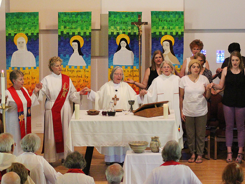 Susan Vaickauski, center right, celebrates Communion alongside Presiding Bishop Joan Clark Houk, center left, of the Great Waters Region of Roman Catholic Womanpriests at her ordination to the priesthood on June 11, 2016, at the Northbrook United Methodist Church in Northbrook, Illinois. RNS photo by Emily McFarlan Miller